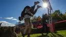 Tim bersiap untuk berlari menjelang North American Wife Carrying Championship di Sunday River Resort di Newry, Maine, pada 8 Oktober 2022. Untuk gaya menggendong, festival ini memiliki 3 jenis gaya, yakni piggyback (gendong di punggung), fireman carry (gendong di bahu) dan estonian style (gendong di punggung namun posisi wanita terbalik dengan kepala di bawah). (Joseph Prezioso / AFP)
