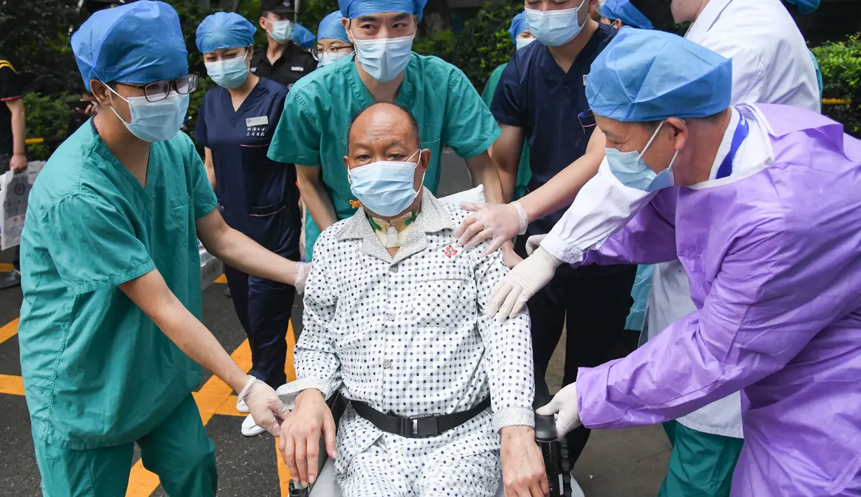 Petugas medis mendampingi Cui saat meninggalkan Rumah Sakit Renmin Universitas Wuhan di Wuhan, Provinsi Hubei, China (21/7/2020). Cui, seorang pasien COVID-19 yang menjalani operasi transplantasi paru-paru ganda, sembuh setelah perawatan selama berbulan-bulan dan dipulangkan. (Xinhua/Cheng Min)