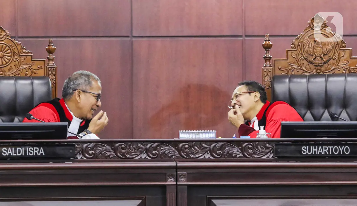 Ketua Mahkamah Konstitusi (MK) Suhartoyo (kanan) berbicara dengan Hakim Konstitusi Saldi Isra (kiri) di sela sidang perkara Nomor 145/PUU-XXI/2023 di Gedung MK, Jakarta, Selasa (16/1/2024). (Liputan6.com/Angga Yuniar)