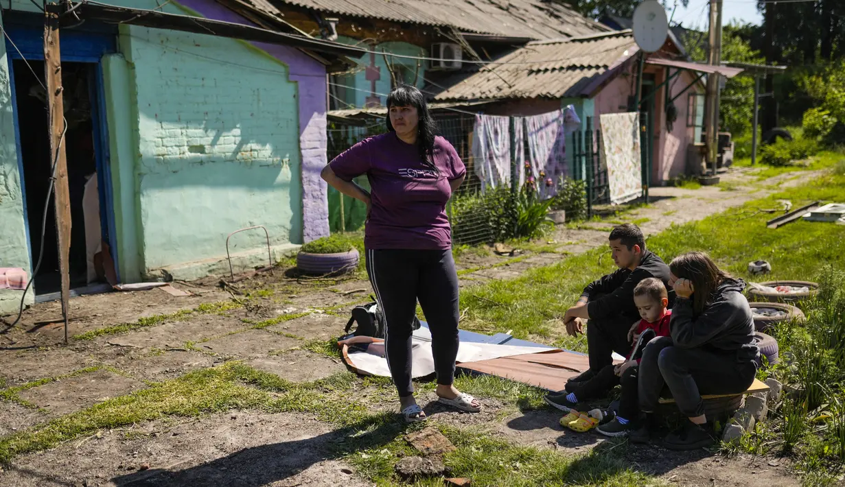 Penduduk setempat berkumpul di luar rumah mereka yang rusak berat setelah serangan Rusia di Pokrovsk, Ukraina timur, Rabu (25/5/2022). Dua roket menghantam kota Pokrovsk, di wilayah Donetsk pada Rabu pagi, menyebabkan sedikitnya empat cedera. (AP Photo/Francisco Seco)