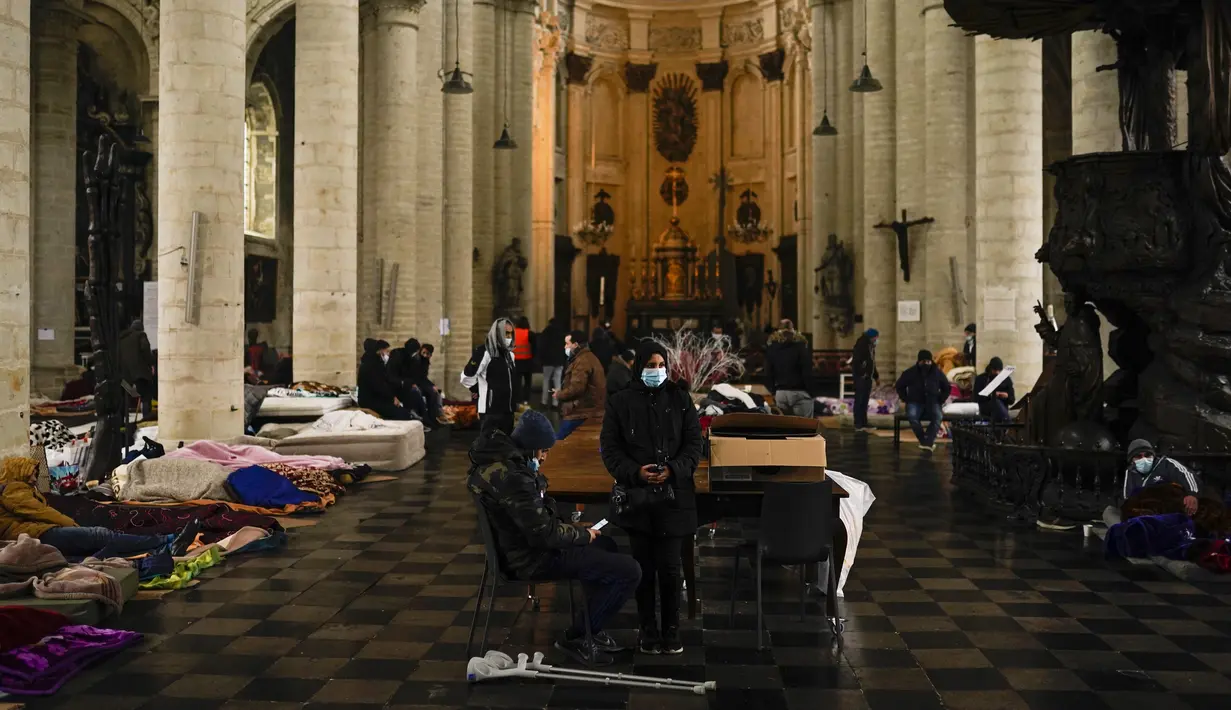 Orang-orang beristirahat di kasur dan mengobrol saat mereka menempati gereja Saint-Jean-Baptiste-au-Beguinage di Brussels, Belgia, Selasa (2/2/2021). Para imigran tanpa surat-surat resmi telah menduduki gereja untuk menarik perhatian otoritas Brussel atas penderitaan mereka. (AP Photo/Francisco Seco