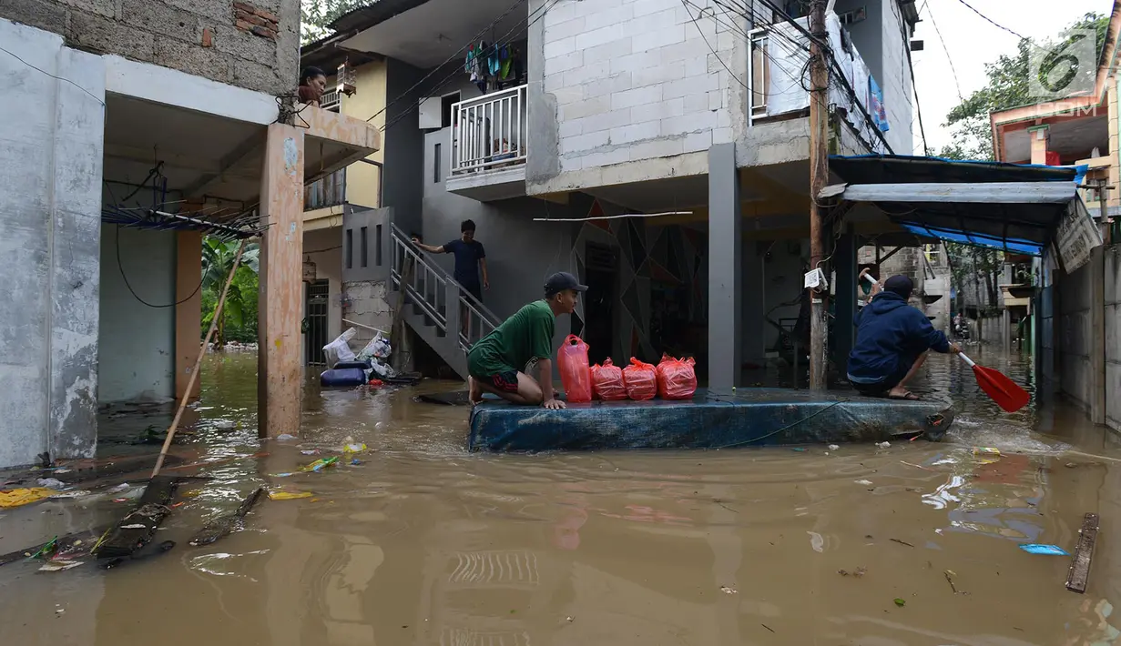 Warga melintasi banjir di kampung Arus Cawang, Jakarta Timur, Jumat (26/4). Ketinggan banjir kurang lebih satu meter terjadi akibat luapan kali Ciliwung dan intensitas curah hujan di kawasan Bogor Jawa Barat sangat tinggi sehingga aktivitas warga terhambat. (merdeka.com/Imam Buhori)