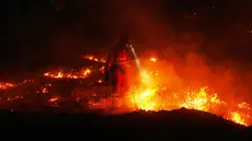 Petugas pemadam kebakaran menggunakan pembakaran terkontrol untuk menghentikan kebakaran hutan yang terus menyebar di dekat Cebreros, provinsi Ávila, Spanyol, Selasa, 28 Juli 2026. (AP Photo/Manu Fernandez)