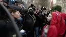 Polisi antihuru-hara menghadang aktivis wanita bertelanjang dada saat aksi protes rompi kuning di Paris, Prancis, Sabtu (15/12). Setelah empat pekan didemo, Presiden Emmanuel Macron kenaikan upah minimum dan konsesi pajak. (AP Photo/Kamil Zihnioglu)