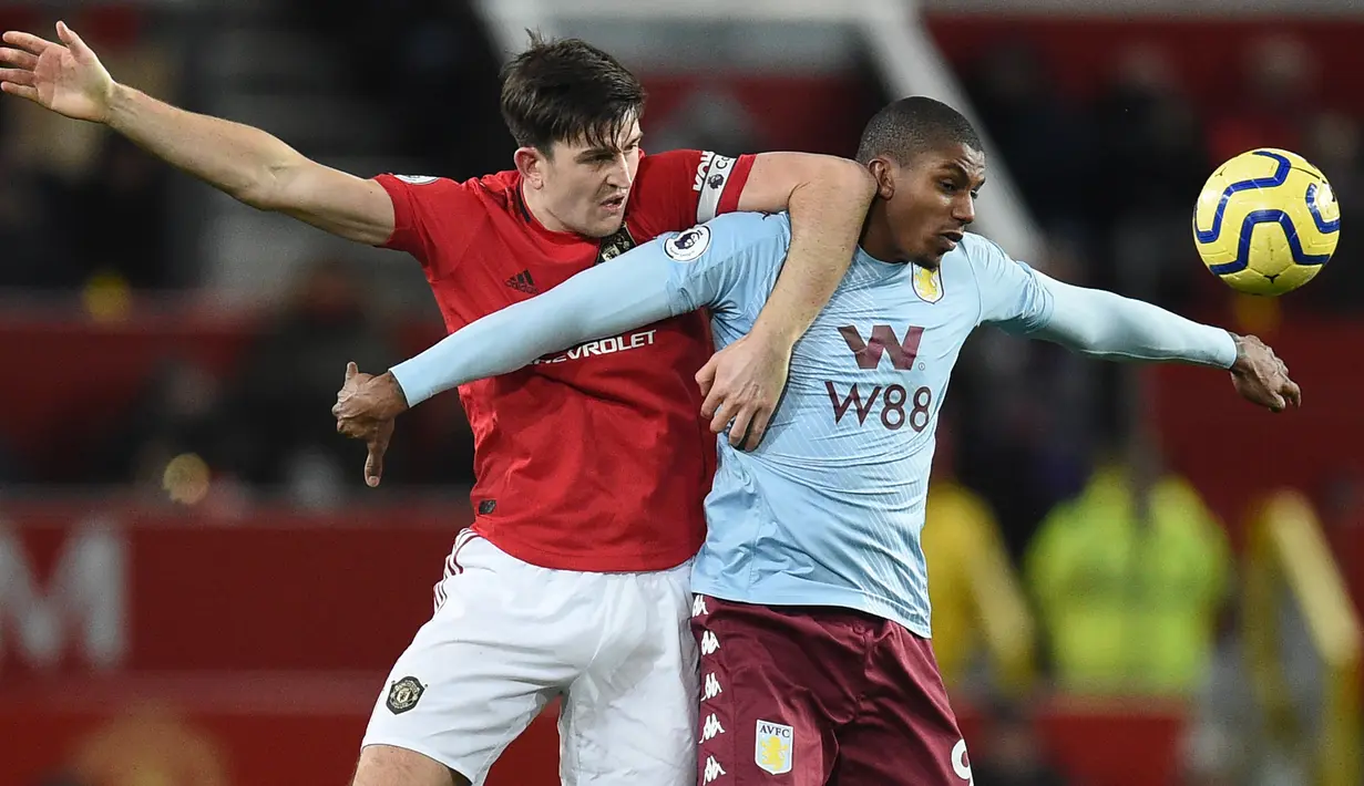 Bek Manchester United, Harry Maguire, berebut bola dengan striker Aston Villa, Wesley, pada laga Premier League di Stadion Old Trafford, Manchester, Minggu (1/12). Kedua klub bermain imbang 2-2. (AFP/Oli Scarff)