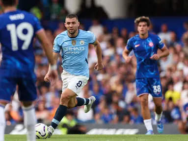 Pemain Manchester City, Mateo Kovacic menggiring bola melewati sejumlah pemain Chelsea pada laga Liga Inggris 2024/2025 di Stamford Bridge, London, Inggris, Minggu (18/08/2024) malam WIB. (AFP/Adrian Dennis)