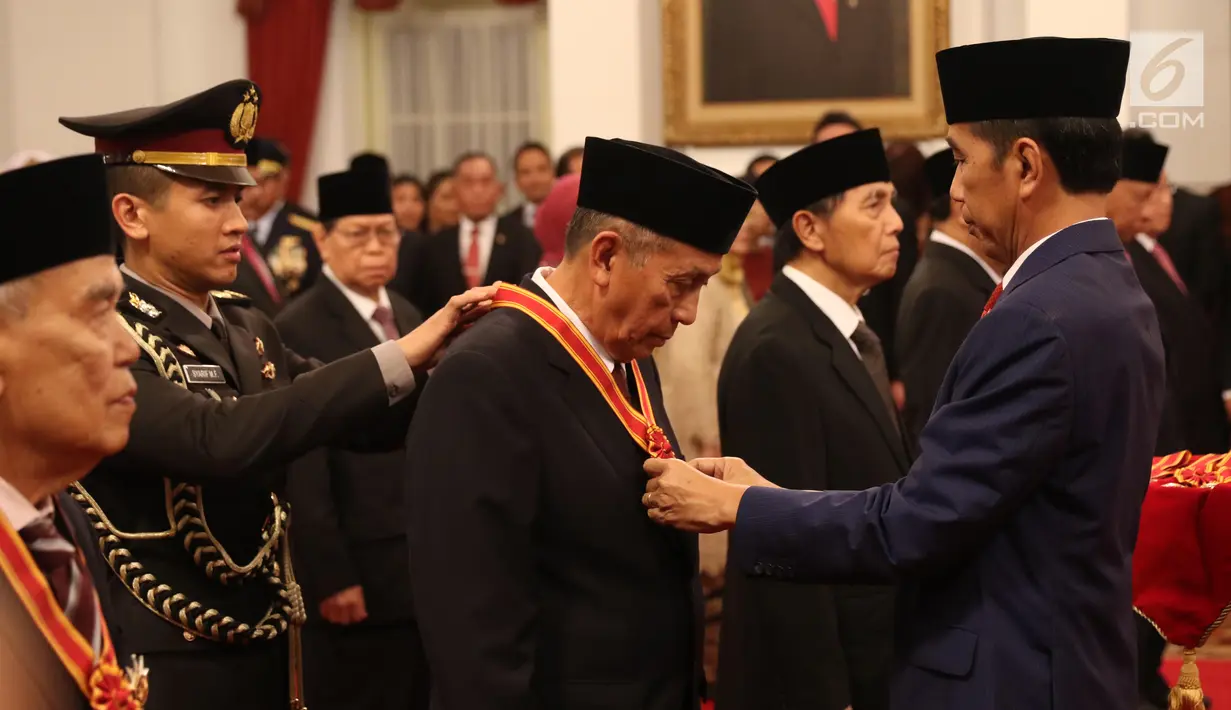 Presiden Joko Widodo atau Jokowi (kanan) menyematkan tanda kehormatan kepada tokoh nasional di Istana Negara, Jakarta, Kamis (15/8/2019). Sebanyak 29 orang mendapat gelar tanda kehormatan Bintang Mahaputra Utama dan Bintang Jasa Utama dalam rangka peringatan HUT ke-74 RI. (Liputan6.com/Angga Yuniar)