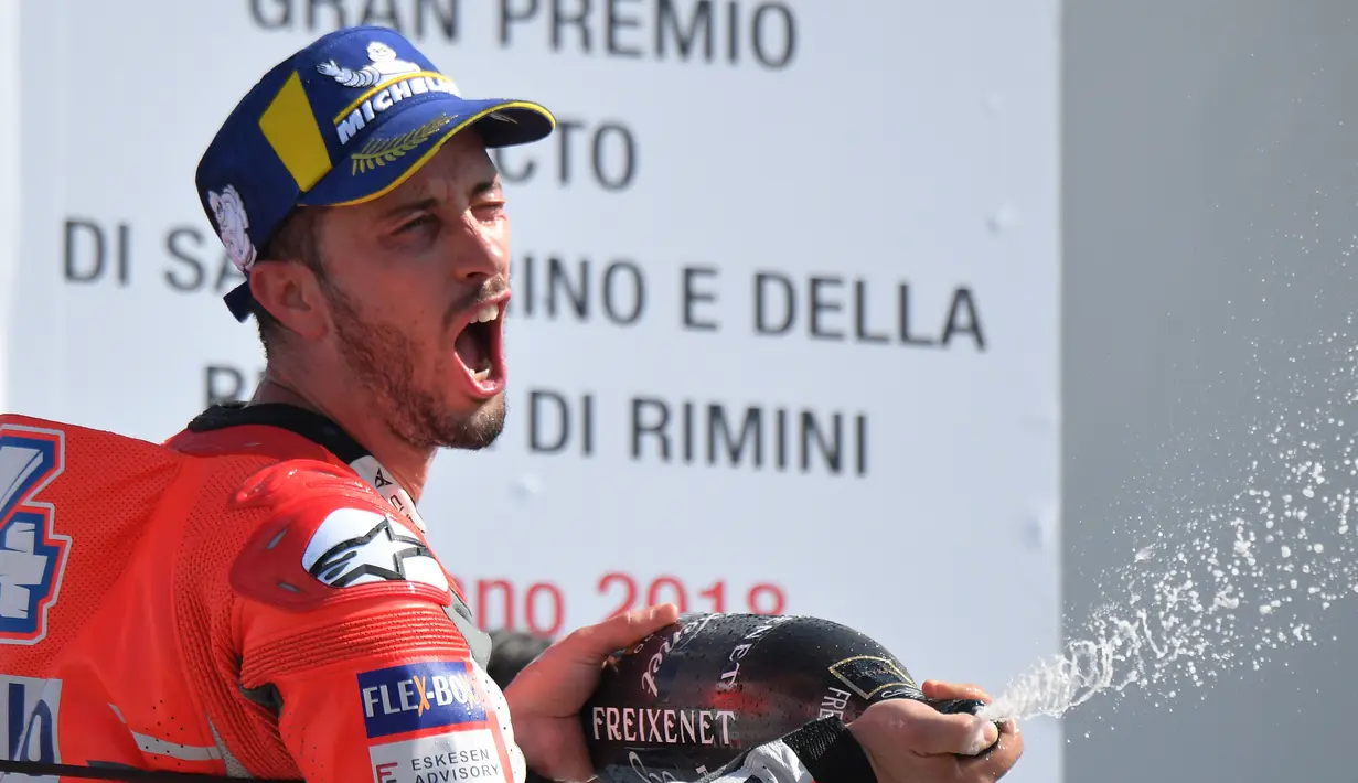 Pembalap Ducati, Andrea Dovizioso merayakan kemenangan dengan menyemprotkan sampanye usai memenangkan balapan MotoGP San Marino di Sirkuit Marco Simoncelli, Misano (9/9). Dovizioso mencetak waktu 42 menit 5,426 detik. (AFP FOTO / Tiziana Fabi)