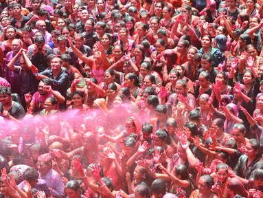 Umat Hindu India disemprot dengan cairan berwarna dalam festival keagamaan Holi di Kuil Swupramayan Kalupur, Ahmedabad, Rabu (20/3). Holi merupakan festival Hindu terbesar di India yang menandai dimulainya musim semi. (SAM PANTHAKY / AFP)