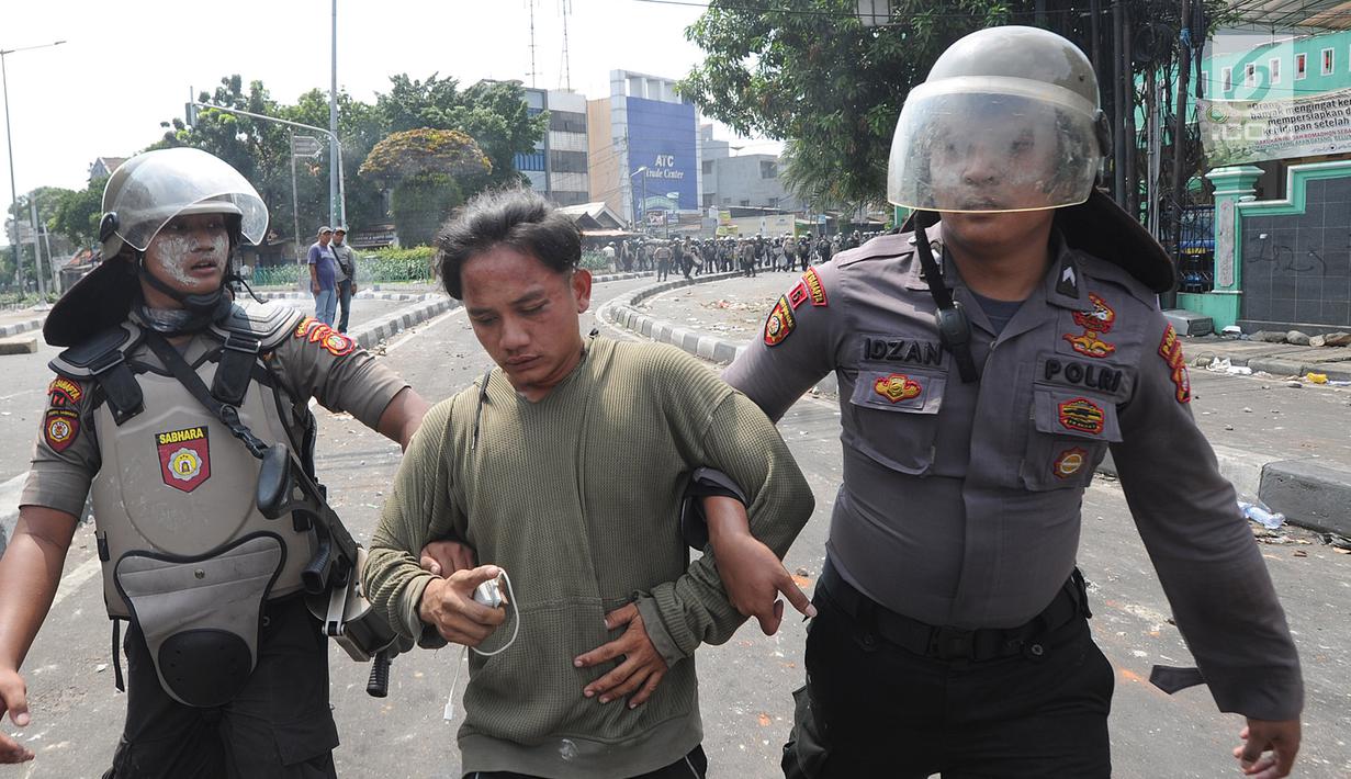 Anggota Sabhara Polri menangkap pengunjuk rasa saat bentrok  dengan massa aksi 22 Mei sebelum terjadi pembakaran bis milik Brimob di kawasan Tanah Abang,  Jakarta, Rabu (22/5/2019). (merdeka.com/Arie Basuki)