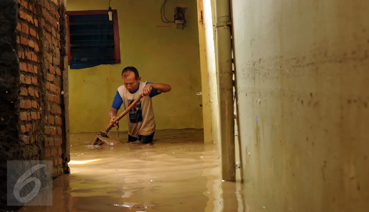 Seorang warga membersihkan sisa lumpur di Rawajati, Kalibata, Jakarta, Senin (16/11/2015).Hujan deras yang melanda Bogor, Minggu (15/11) mengakibatkan puluhan rumah warga di bantaran sungai Ciliwung terendam. (Liputan6.com/Helmi Fithriansyah)