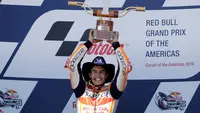 Pembalap Repsol Honda, Marc Marquez mengangkat trofi juara MotoGP Amerika di Circuit of the Americas (COTA), Austin, Minggu (22/4). Sebelum lomba, Marquez kena hukuman mundur tiga posisi karena melakukan pelanggaran di sesi kualifikasi. (AP/Eric Gay)