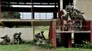 Sejumlah tentara Italia berusaha masuk ke dalam sebuah bangunan saat mengikuti latihan militer di sebuah kamp pelatihan di Tarquinia, dekat Roma, (21/5).  (AFP Photo/Tiziana Fabi)