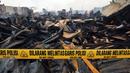 Garis polisi terpasang di lokasi kebakaran yang melanda wilayah permukiman di Jalan Gotong Royong, RW 002 Pondok Bambu, Jakarta, Senin (8/8). Polisi masih mengusut penyebab kebakaran yang menghanguskan 90 rumah tersebut. (Liputan6.com/Johan Tallo)