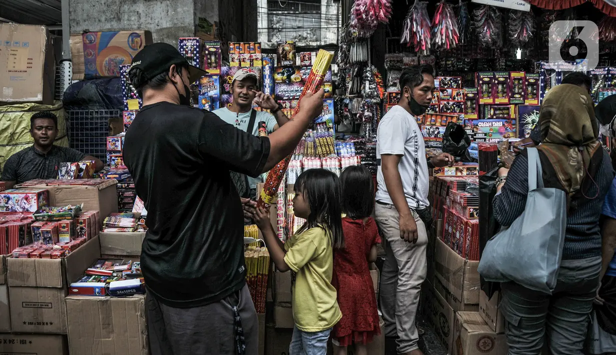 Anak-anak dan orang tua mereka melihat kembang api yang dijual di Pasar Asemka, Jakarta, Selasa (28/12/2021). Sejumlah pedagang petasan dan kembang api mulai ramai di Asemka meskipun Pemprov DKI dan Polda Metro Jaya melarang penjualan serta perayaan malam Tahun Baru. (merdeka.com/Iqbal S Nugroho)