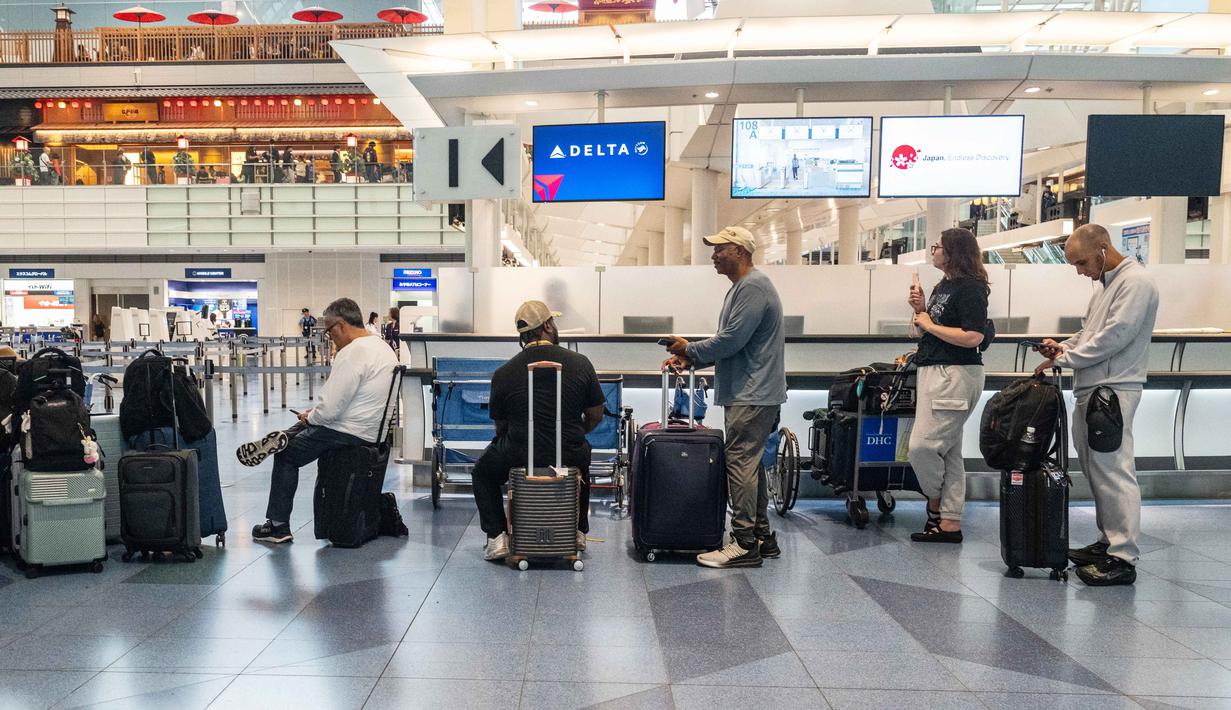 Penumpang menunggu di Terminal Internasional Bandara Haneda setelah penerbangan dibatalkan atau ditunda karena badai tropis Jangmi di Tokyo, Jepang, Rabu 3 Juni 2026. (Andrew CAALLERO-REYNOLDS/AFP)