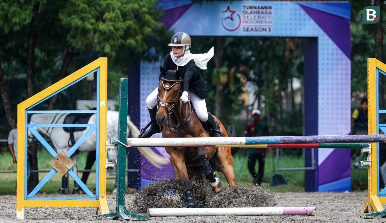 Selebritas Indonesia, Zaskia Sungkar berusaha mengendalikan kudanya saat berkompetisi dalam cabang olahraga berkuda nomor show jumping Turnamen Olahraga Selebriti Indonesia (TOSI) Season 3 yang berlangsung di Arthayasa Stable, Depok, Jawa Barat, Jumat (01/11/2024). (Bola.com/Bagaskara Lazuardi)