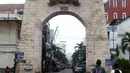 Dua orang pelajar berjalan di depan gerbang kawasan Pasar Baru, Jakarta, Kamis (22/9/2022). Penetapan Kompleks Pasar Baru sebagai Situs Cagar Budaya dikarenakan bangunan pada kawasan ini memiliki struktur cagar budaya yang menyimpan informasi mengenai kegiatan manusia pada masa lalu. (Liputan6.com/Helmi Fithriansyah)