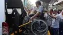 Seorang penyandang disabilitas saat menaiki mobil akses untuk disabilitas di Gedung Mandiri, Jakarta, Sabtu (2/7). Sebanyak 1200 pemudik diberangkatkan dengan 25 bus dan satu unit mobil akses untuk disabilitas (14 Orang). (Liputan6.com/Faizal Fanani)