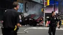 Petugas kepolisian berada dekat sebuah mobil yang menabrak para pejalan kaki di trotoar Times Square, New York, Kamis (18/5). Mobil tersebut melaju kencang ke arah jalur pejalan kaki dan menabrak kerumunan hingga menewaskan satu orang. (Jewel SAMAD/AFP)