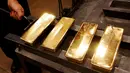 Seorang pekerja mengangkat emas batangan 99,99 murni yang selesai dicetak di pabrik logam mulia Krastsvetmet, Rusia, 24 Oktober 2016. Krastsvetmet merupakan salah satu produsen terbesar di dunia dalam industri logam mulia (Reuters/Ilya Naymushin)