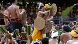 Dua orang laki-laki saling pukul dengan daun pandan yang berduri saat mengikuti Perang Pandan di Bali (8/6). Perang Pandan juga disebut dengan istilah Makere-kere. (AP/Firdia Lisnawati)
