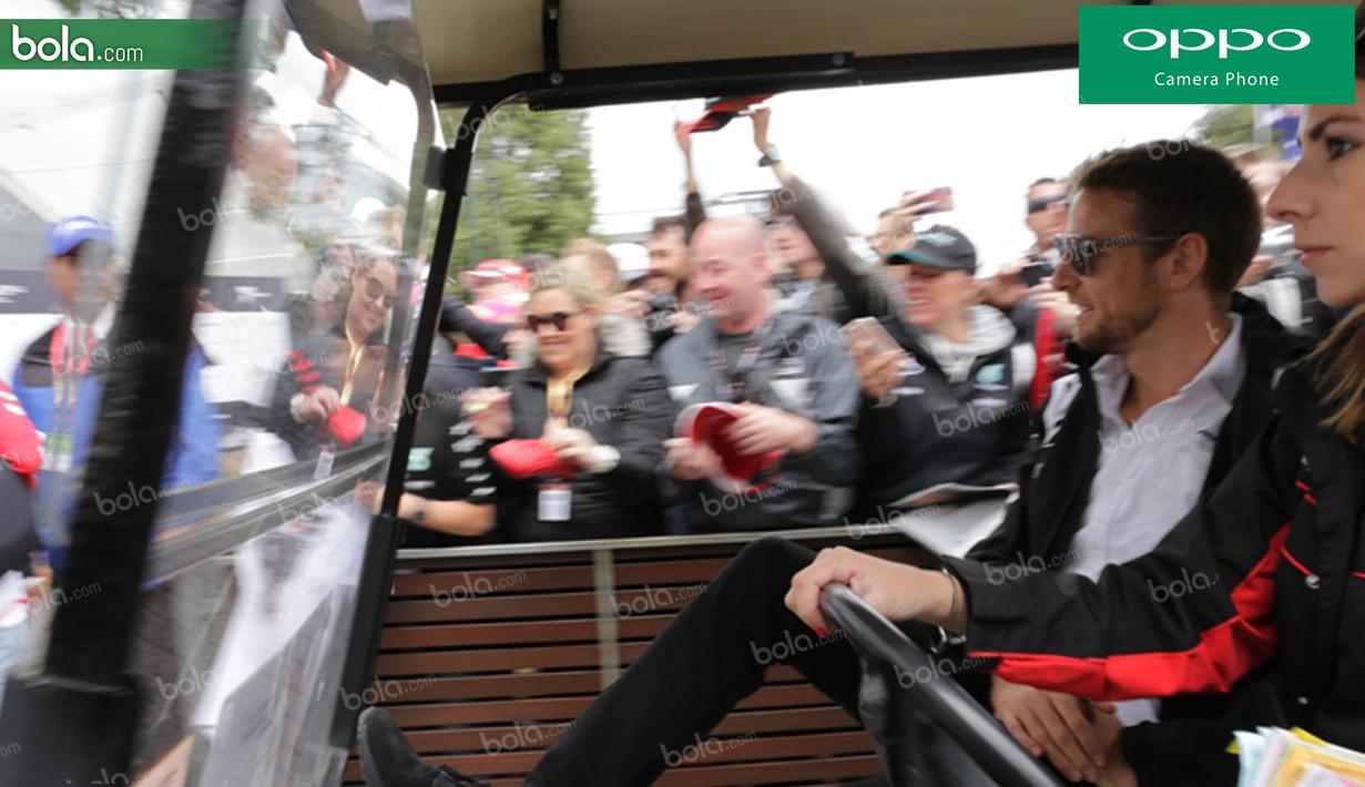 Pebalap McLaren asal Inggris, Jenson Button, melempar senyumnya kepada penggemar saat melintasi area fan zone jelang GP Australia di Sirkuit Albert Park, Melbourne, Sabtu (19/3/2016). (Bola.com/Yus Mei Sawitri)