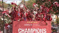 Para pemain Liverpool menyapa fans saat parade juara Liga Champions 2019 di Liverpool, Minggu (2/6). Ribuan fans tumpah ruah di jalanan untuk merayakan keberhasilan pemain membawa pulang trofi Si Kuping Besar ke kota Liverpool. (AP/Barrington Coombs)