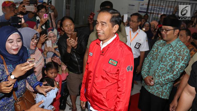 Presiden Joko Widodo menyapa para calon penumpang saat kunjungan kerja di Stasiun Cibatu, Garut, Jumat (18/1). Kedatangan Jokowi yang didampingi Ibu Negara Iriana  itu untuk meninjau reaktivasi jalur kereta api Cibatu-Garut. (Liputan6.com/Angga Yuniar)