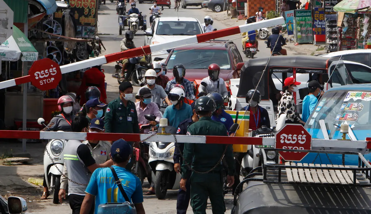 Orang-orang diblokir oleh petugas polisi setempat untuk masuk ke jalan kota utama dekat bandara Internasional Phnom Penh di Phnom Penh, Kamis (15/4/2021). Pemimpin Kamboja memutuskan untuk lockdown Phnom Penh selama dua minggu menyusul kenaikan tajam kasus COVID-19. (AP Photo/Heng Sinith)