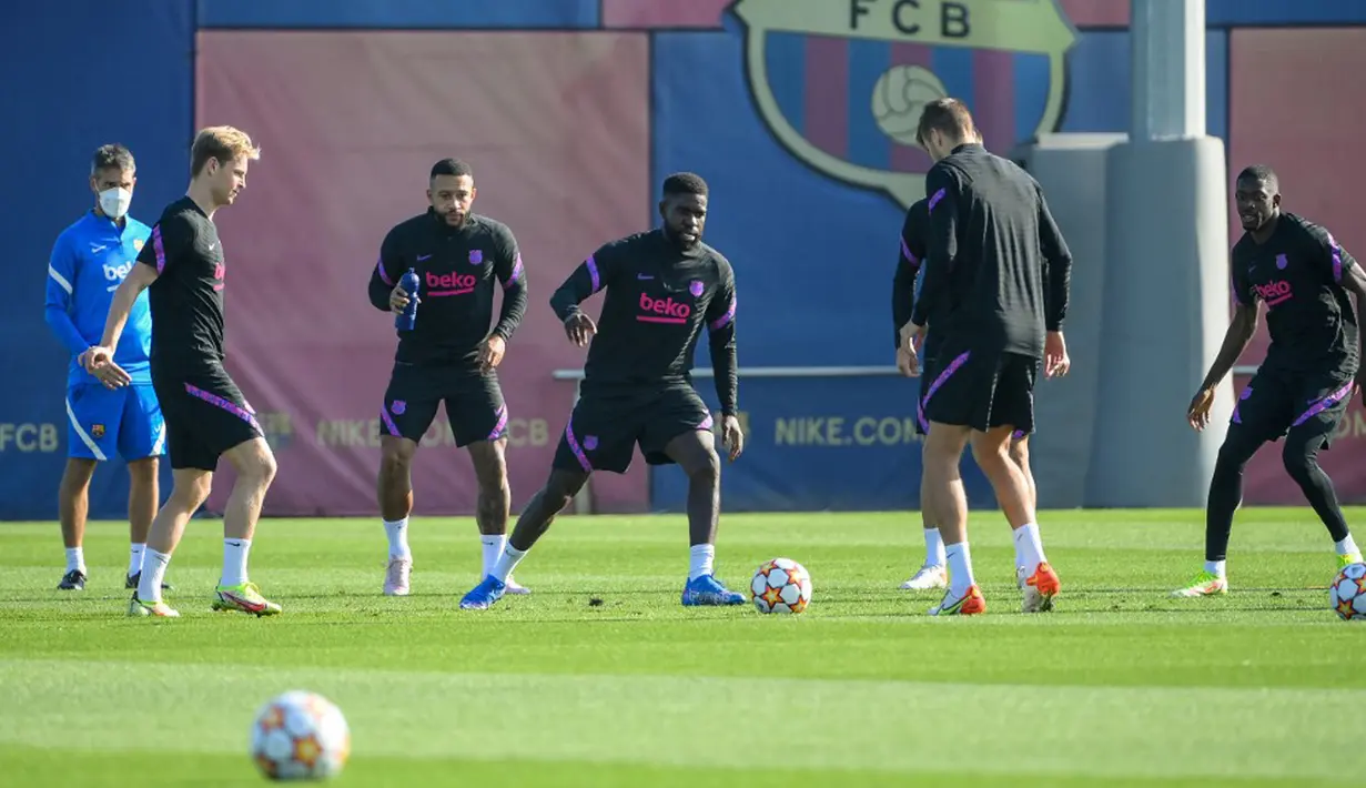 Pemain Barcelona Memphis Depay (kiri) dan Samuel Umtiti (tengah) bersama rekan satu tim mereka saat sesi latihan di Barcelona, Spanyol, Selasa (19/10/2021). Barcelona akan menghadapi Dynamo Kiev pada pertandingan Grup E Liga Champions. (LLUIS GENE/AFP)
