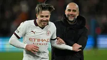 Selebrasi kemenangan gelandang Manchester City, Jack Grealish bersama pelatih Pep Guardiola setelah mengalahkan Luton Town 2-1 pada laga pekan ke-16 Liga Inggris 2023/2024 di Kenilworth Road, Luton, Minggu (10/12/2023) malam WIB. (AFP/Justin Tallis)
