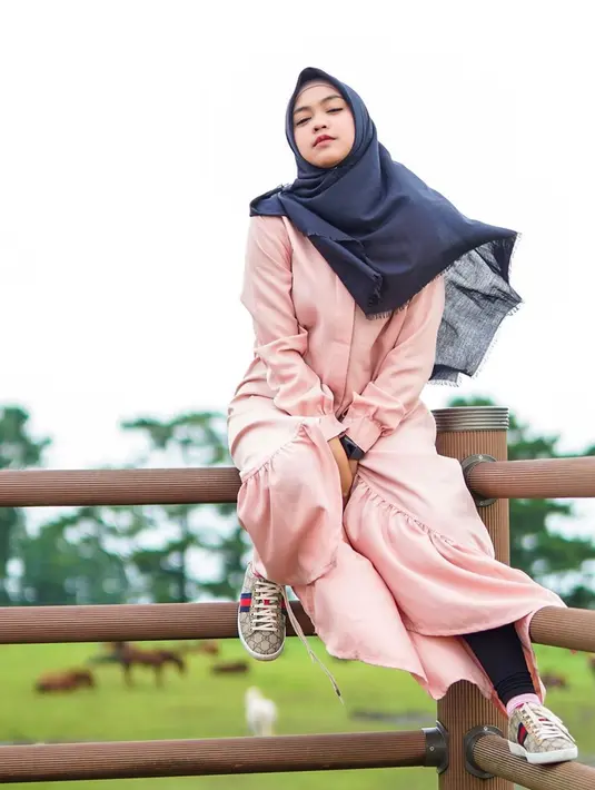 Youtuber dengan jumlah subscriber terbanyak kedua di Indonesia ini tampak santai saat liburan di Korea. Menggunakan busana muslim berwarna pink, dilengkapi dengan hijab berwarna hitam yang dihembus angin, ia tampak menawan. (Liputan6.com/IG/@riaricis1795)