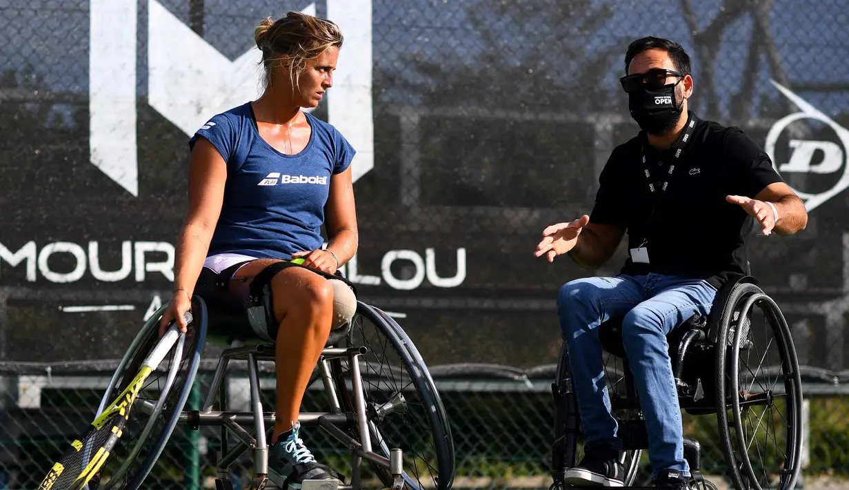 Atlet para tenis Prancis Pauline Deroulede berlatih bersama mantan peraih medali ganda dunia N.1 Michael Jeremiasz saat edisi ke-4 turnamen tenis kursi roda French Riviera Open di Biot, 28 September 2020. Korban kecelakaan itu kehilangan kaki kirinya pada Oktober 2018. (FRANCK FIFE/AFP)