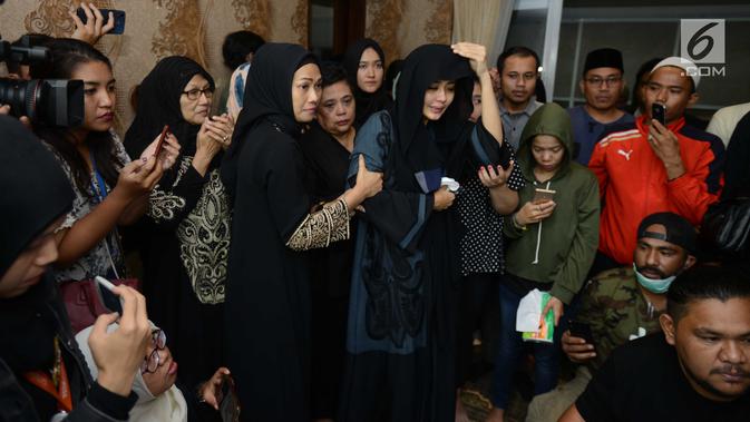 Istri gitaris grup band Seventeen Herman Sikumbang, Juliana Muhtar menangis saat menerima kedatangan jenazah suami di rumah duka di Pancoran, Jakarta Selatan, Senin (24/12). Uli tak henti meneteskan air mata. (Kapanlagi.com/Bayu Herdianto)