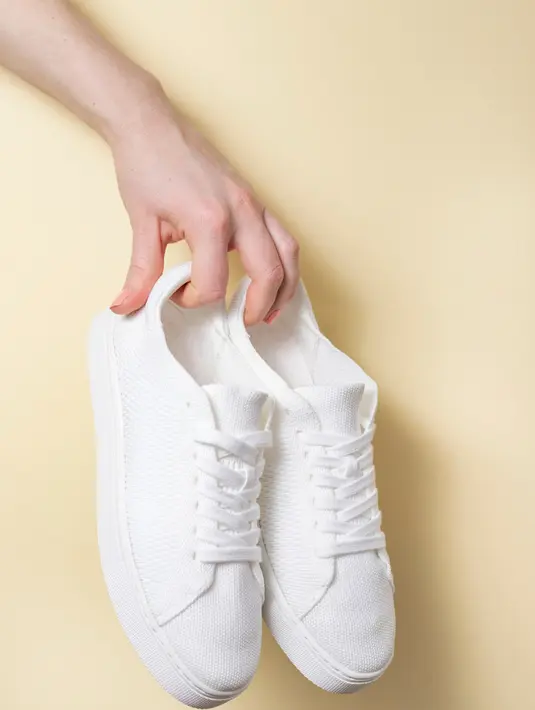 White Sneakers. Sneakers berwarna putih dengan bahan canvas atau leather adalah pilihan sepatu yang klasik.  White sneakers ini bisa buat penampilan kamu jadi level up dan mudah banget untuk di mix & match. / copyright shutterstock