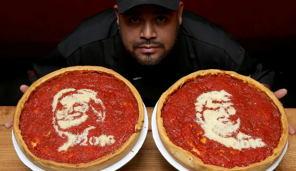 Chief Cook, Fabian Martinez berpose dengan pizza bergambar wajah calon presiden AS dari Partai Republik, Donald Trump dan rivalnya dari Partai Demokrat, Hillary Clinton di Giordano Pizzeria, Chicago, Selasa (27/9). (REUTERS / Jim Young)