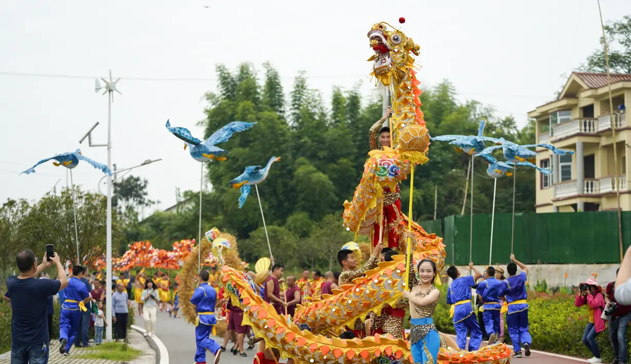 Warga desa menampilkan pertunjukan tari naga di Distrik Tongliang di Chongqing, China barat daya (19/9/2020). Pertunjukan tari naga dan kegiatan rakyat lainnya digelar untuk merayakan festival panen petani China yang jatuh pada Equinox Musim Gugur setiap tahunnya. (Xinhua/Liu Chan)