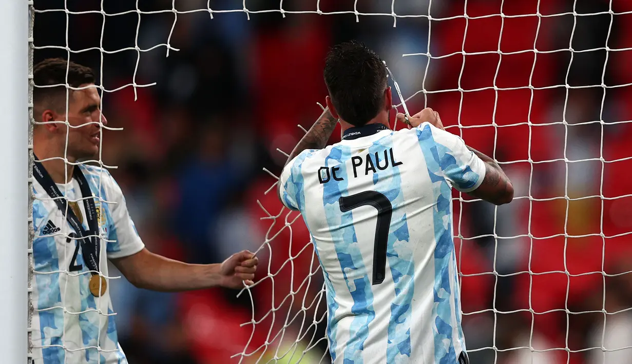 Pemain Argentina, Rodrigo De Paul (kanan) dan Giovani Lo Celso memotong jaring gawang setelah memenangkan laga Finalissima melawan Italia dengan skor 3-0 di Stadion Wembley, Kamis (02/06/2022) dini hari WIB. Gol La Albiceleste masing-masing dicetak oleh Lautaro Martinez (28'), Angel Di Maria (45+1'), dan Paulo Dybala (90+4'). (AFP/Adrian Dennis)