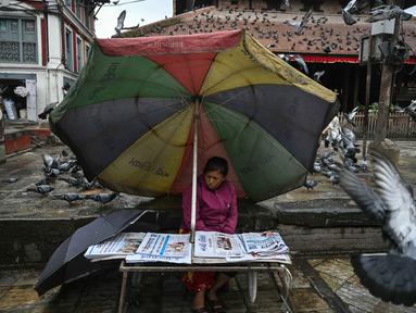 Seorang penjual koran terlihat duduk di tepi jalan di Durbar Square, Kathmandu, Nepal pada 13 September 2025. (Arun SANKAR/AFP)