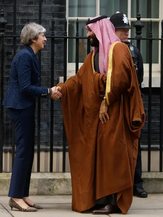 Perdana Menteri Inggris, Theresa May menjabat tangan Putra Mahkota Arab Saudi, Pangeran Mohammed bin Salman saat menyambut kunjungannya di 10 Downing Street, London, Rabu (7/3). Inggris menyambut hangat kunjungan Pangeran Saudi itu. (AP/Alastair Grant)