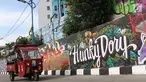 Pengendara melintasi jalur inspeksi Sungai Ciliwung di Jakarta, Kamis (27/12). Mural yang dibuat oleh beberapa komunitas tersebut menjadikan jalur inspeksi Sungai Ciliwung tampak lebih berwarna dan asri. (Liputan6.com/Immanuel Antonius)