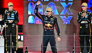 Juara dunia dan pembalap McLaren asal Inggris, Lando Norris (kanan), menyaksikan pembalap Red Bull Racing asal Belanda, Max Verstappen (tengah), merayakan kemenangan di samping pembalap McLaren asal Australia, Oscar Piastri, yang berada di podium pada akhir Grand Prix Formula Satu Abu Dhabi di Sirkuit Yas Marina, Abu Dhabi, 7 Desember 2025. (Giuseppe CACACE/AFP)