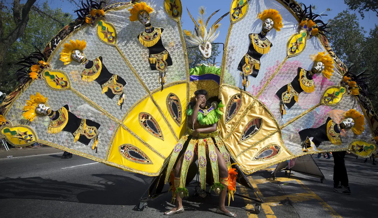 Seorang partisipan menutup wajahnya dari sinar matahari saat mengikuti West Indian Day Parade di Brooklyn, New York, Senin (7/9/2015). Parade yang berlangsung tiap tahun ini merayakan budaya Karibia dan sejarah. (REUTERS/Andrew Kelly)