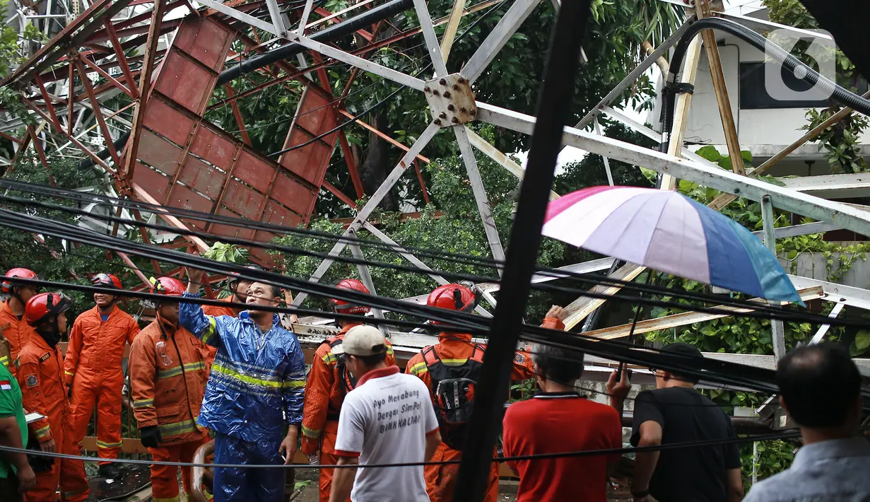 Petugas memeriksa kondisi menara Base Transceiver Station (BTS) milik Radio Republik Indonesia (RRI) yang roboh di kawasan Radio Dalam, Kebayoran Baru, Jakarta Selatan, Minggu (22/12/2019. Menara yang roboh menimpa rumah, masjid, kendaraan, dan melukai seorang warga. (Liputan6.com/Herman Zakharia)
