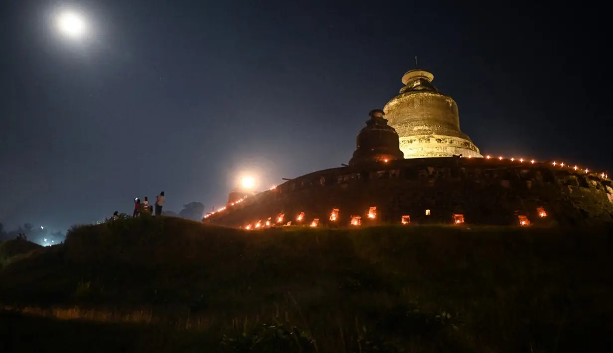 Pemandangan saat orang-orang mengambil bagian dalam Festival Tazaungdaing di pagoda di Mrauk U, Rakhine, Myanmar, 18 November 2021. Tazaungdaing adalah Festival Bulan Purnama yang diadakan setiap tahun pada bulan purnama, bulan kedelapan dalam kalender Burma. (STR/AFP)