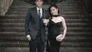 Prilly memilih gaun hitam berpotongan one-shoulder dengan aksen bustier yang memberi kesan klasik sekaligus sensual. Detail embellishment halus pada bagian bodice menambah kesan mewah, sementara belahan tinggi di bagian rok memberikan sentuhan dramatis yang tetap sophisticated. Gaun ini mempertegas siluet tubuhnya dengan cutting yang pas dan elegan.