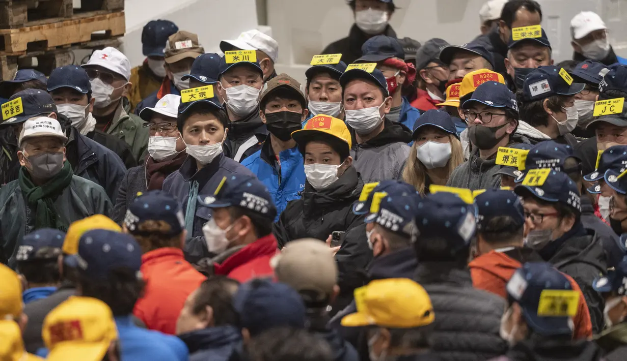 Penjual dan pembeli grosir menghadiri lelang tuna pertama Tahun Baru di pasar ikan Toyosu di Tokyo (5/1/2023). Pada tahun ini, lelang tuna tertinggi terjual lebih dari USD 270.000. Hampir dua kali lipat dari harga tahun lalu. (AFP/Richard A. Brooks)