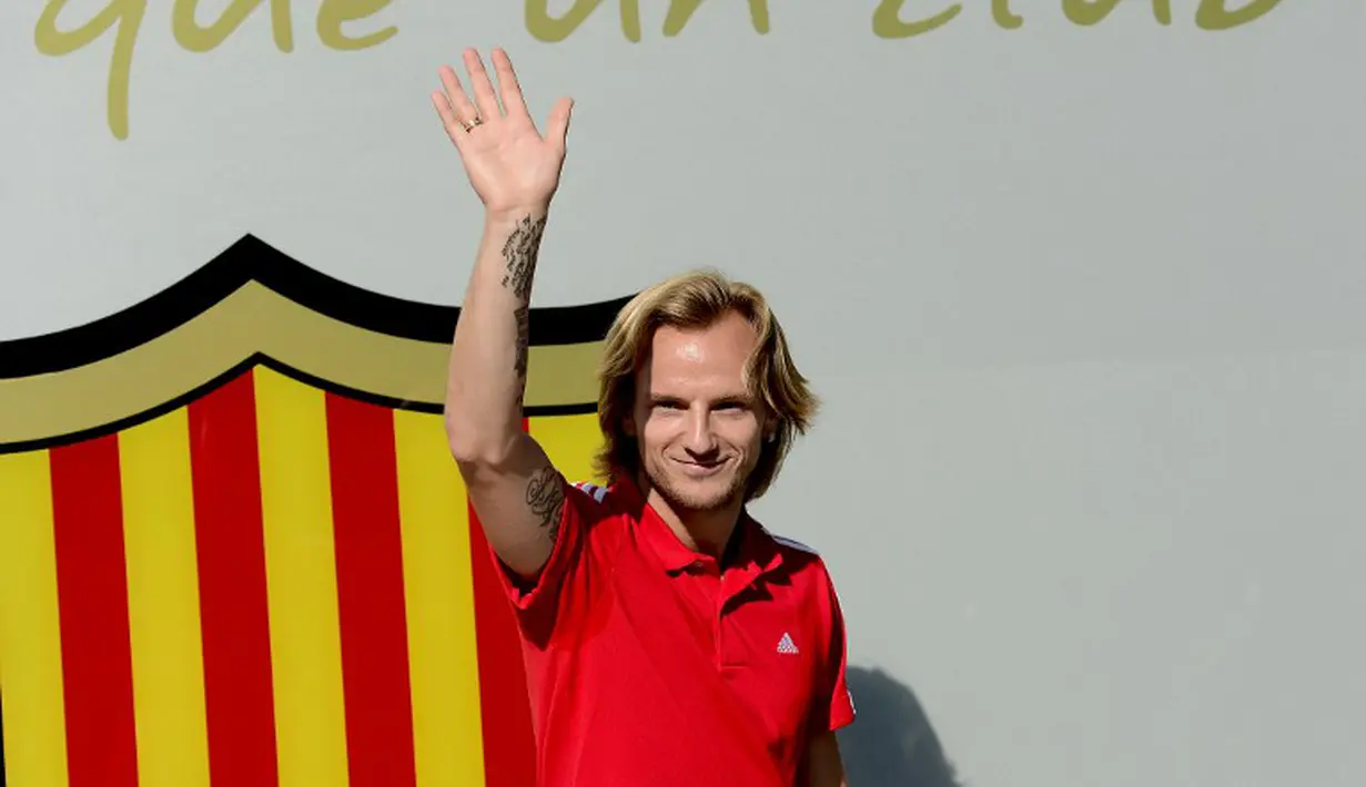 Ivan Rakitic melambaikan tangan kepada puluhan jurnalis dan fotografer yang menunggunya di depan kantor klub, Spanyol, Senin (30/6/14). (AFP PHOTO/Josep Lago)