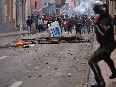 Polisi anti huru hara saat menghadapi demonstran selama bentrokan di Quito (7/10/2019). Para demonstran memprotes terhadap keputusan Presiden Ekuador Lenin Moreno yang mencabut subsidi bahan bakar. (AFP Photo/Cristina Vega)